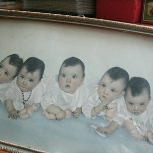 vintage Dionne quintuplets in a frame with glass.